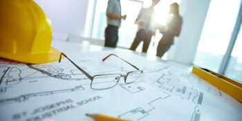 Engineering objects Image of engineering objects on workplace with three partners interacting on background